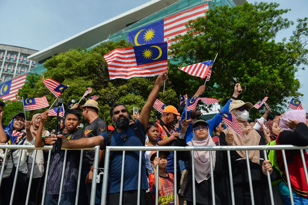 File picture of attendees waving Malaysian flags as they watch a parade during National Day celebrations in Putrajaya on August 31, 2023. Chief statistician Datuk Seri Mohd Uzir Mahidin in a statement today said the total population comprised 90 per cent or 30.6 million citizens and 10 per cent or 3.4 million non-citizens. — Picture by Miera Zulyana