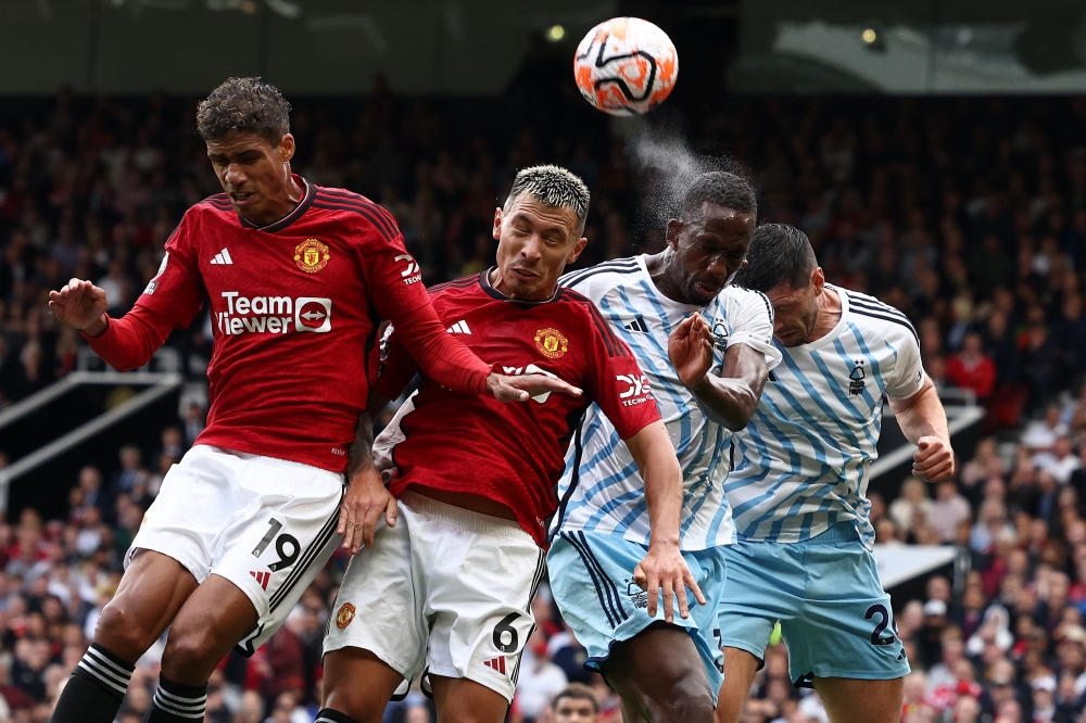 Manchester United defenders Raphael Varane and Lisandro Martinez head the ball with Nottingham Forest defenders Willy Boly and Scott McKenna at Old Trafford in Manchester in this file picture on August 26, 2023. — AFP pic