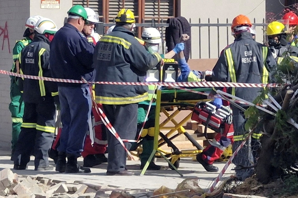 A man raises his hand as rescue workers carry him to an ambulance after being rescued, having survived 118 hours after a deadly building collapse in George, South Africa May 11, 2024. — Garden Route District Municipality handout via Reuters 