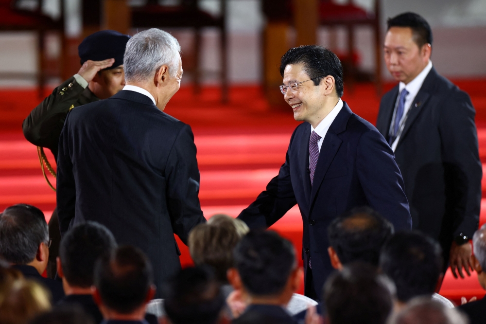 Singapore's Deputy Prime Minister and Minister of Finance Lawrence Wong shakes hands with Senior Minister Lee Hsien Loong on the day he is sworn in as Singapore's fourth Prime Minister at the Istana, in Singapore, May 15, 2024. — Reuters pic