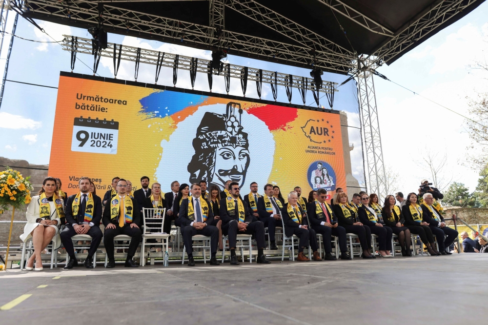 AUR European Parliament candidates, near a poster depicting Vlad Tepes, the 15th-century ruler who inspired Bram Stoker's Count Dracula, sit on stage during an event held in Targoviste, Dambovita county, Romania, April 7, 2024. — Inquam Photos/George Calin via Reuters