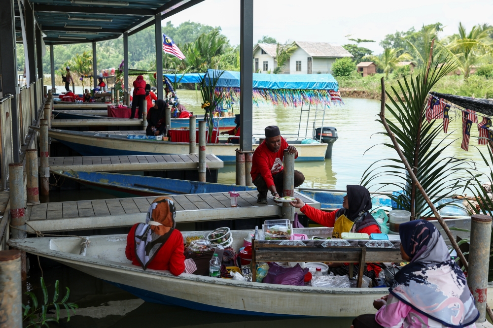 Traders sell various types of food on boats at Pulau Suri Floating Market May 16, 2024. — Bernama pic