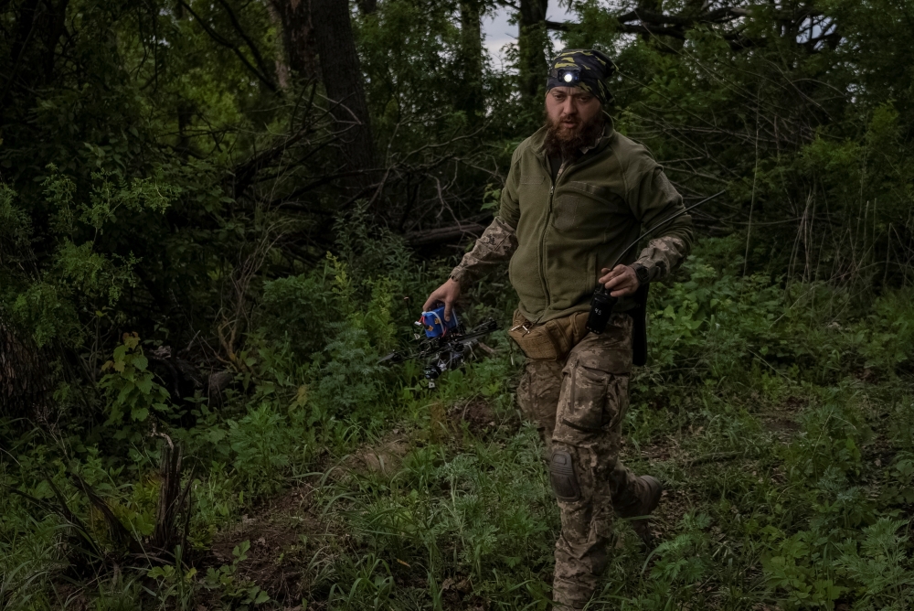 A Ukrainian serviceman of the attack drones battalion of the Achilles, 92nd brigade carries a first person view (FPV) drone before it flies, near a Russian border in a Kharkiv region, Ukraine May 15, 2024. — Reuters pic