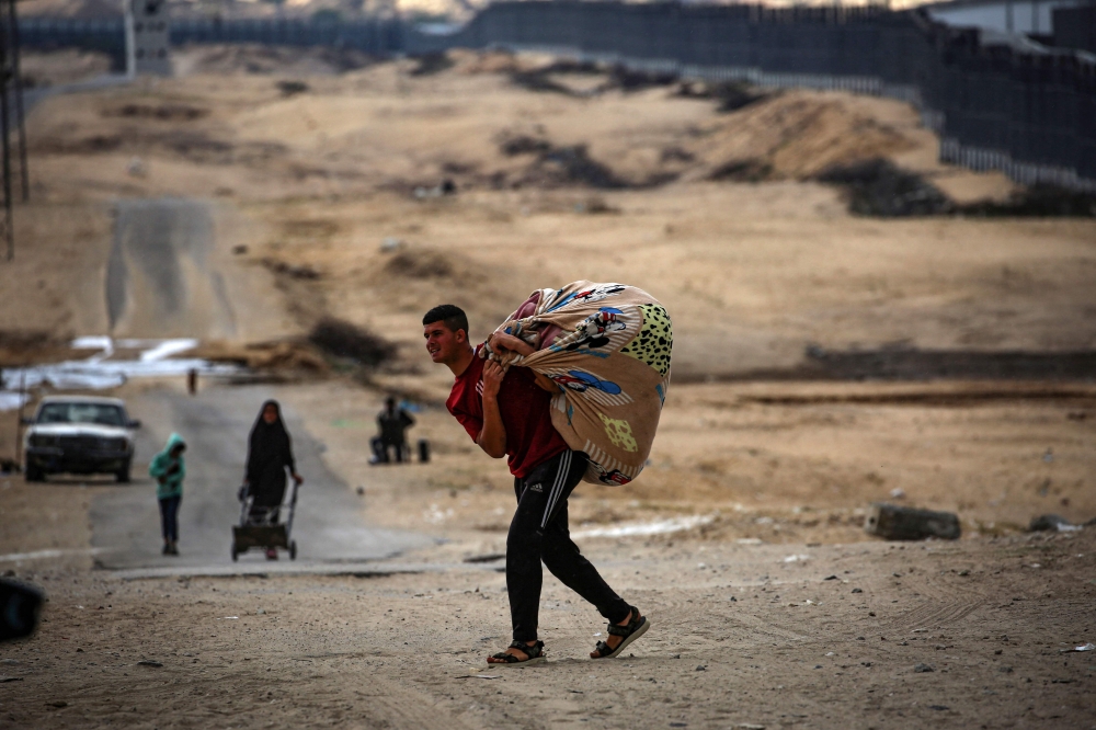 Palestinians carry their belongings as they prepare to flee Rafah in the southern Gaza Strip on May 13, 2024, amid the ongoing conflict between Israel and the Hamas militant group. — AFP pic