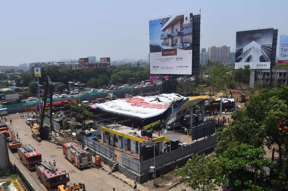 Emergency vehicles are seen parked at the site a day after an advertisement billboard collapsed over a petrol station following a storm, in Mumbai on May 14, 2024. — AFP pic