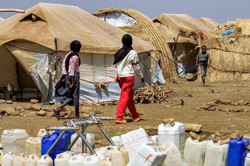 Girls walk past tents at a camp for people displaced by conflict in Sudan's eastern Gedaref province on May 15, 2024. — AFP pic