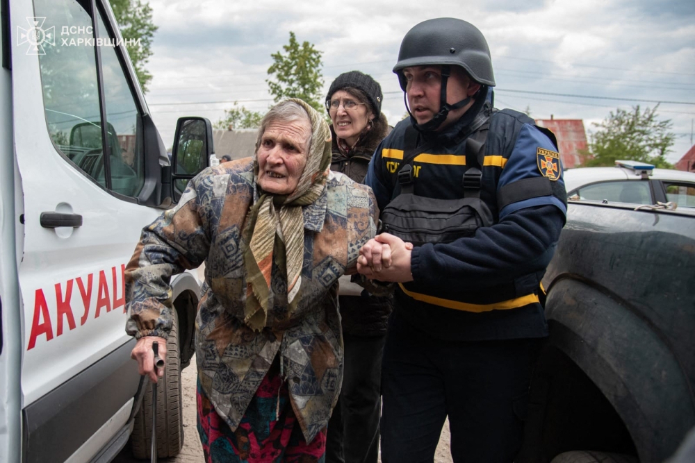 This handout photograph taken and released by Ukrainian Emergency Service on May 17, 2024, shows rescuers evacuating an elderly civilian from Russian shelling in Kharkiv region. —  Handout / Ukraine Emergency Service / AFP pic