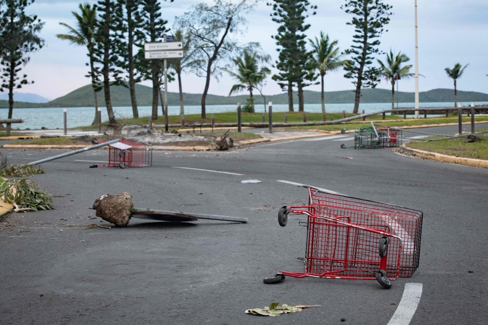 Shopping trolleys lie abandon on the street after a supermarket was looted and shops vandalised in Noumea. — AFP pic