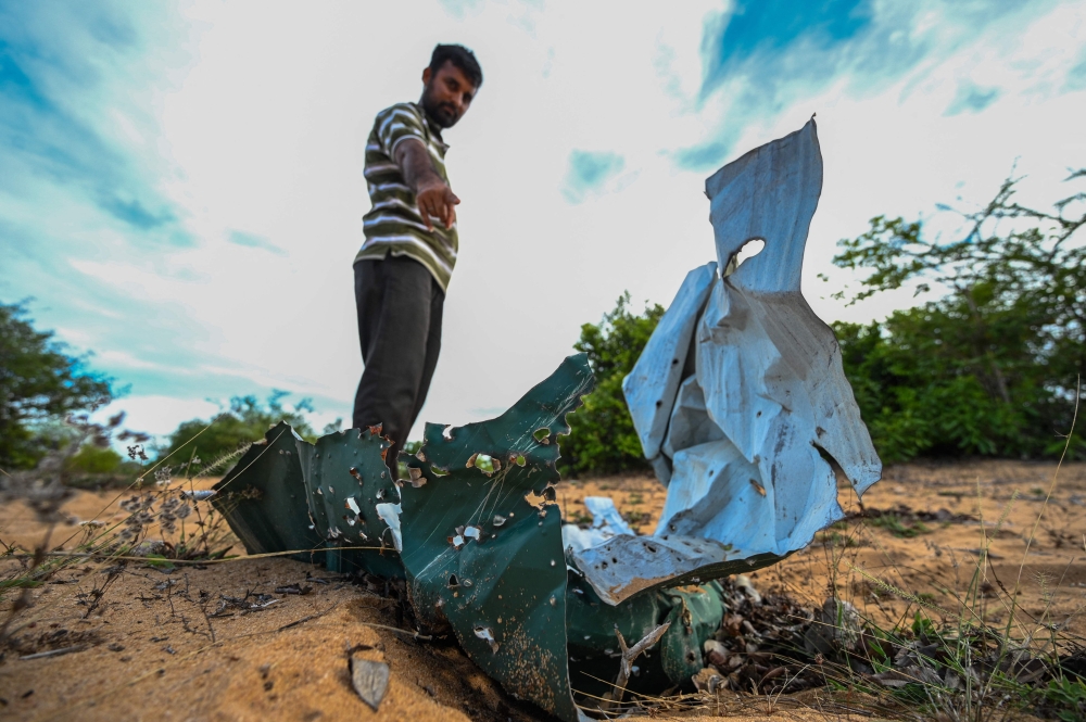 A Tamil resident points to what is left of a bunker built by civilians to escape fighting between government troops and Tamil rebels during the final stages of the Island’s separatist war in Mullivaikkal, in north-eastern Sri Lanka on May 17, 2024. — AFP pic