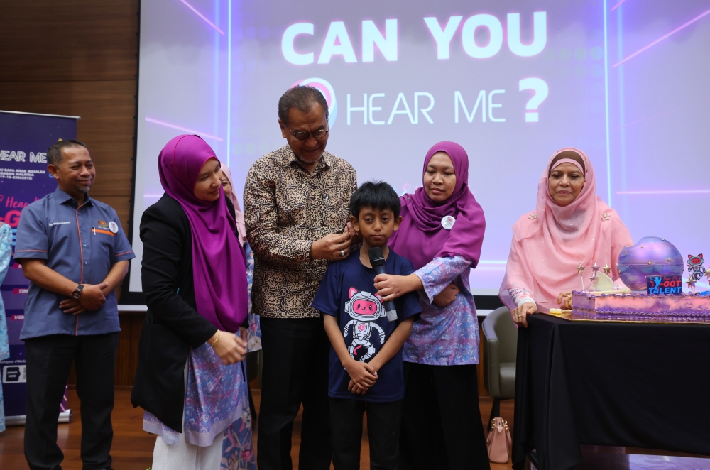 Health Minister Datuk Seri Dzulkefly Ahmad (3rd left) puts on a hearing aid on a recipient during the launch of the Hear Me’s Got Talent programme at the Cyberjaya Hospital May 18, 2024. — Bernama pic