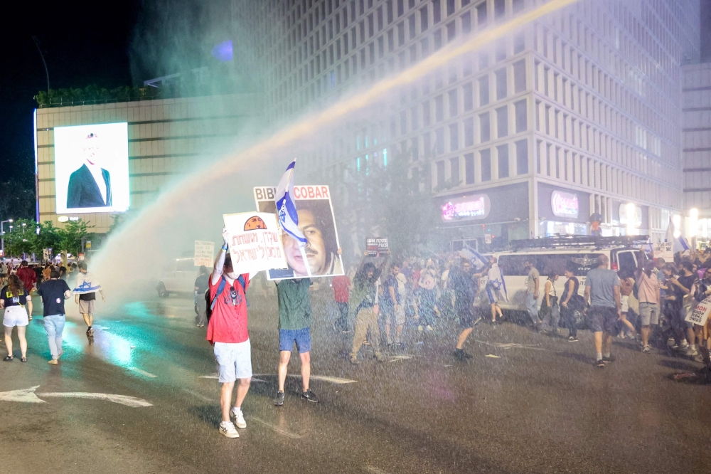Israeli police use a water cannon to disperse protestors as thousands rallied in Tel Aviv calling on the authorities to bring the remaining hostages back home. — AFP pic