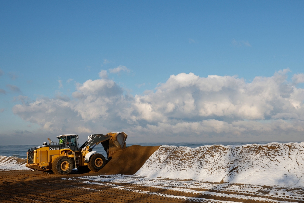 Bulldozers move sand during a beach replenishment operation in the Mount Baldy area of Indiana Dunes National Park November 1, 2023. At Indiana Dunes National Park, beaches are submerged, and the namesake dunes are collapsing. Yet, unlike the doomed glaciers, park workers are fighting back. Every year, they fill in a damaged site along the southern shore of Lake Michigan, where the park's unique biodiversity thrives amidst surrounding steel mills and a coal-fired power station. — AFP pic