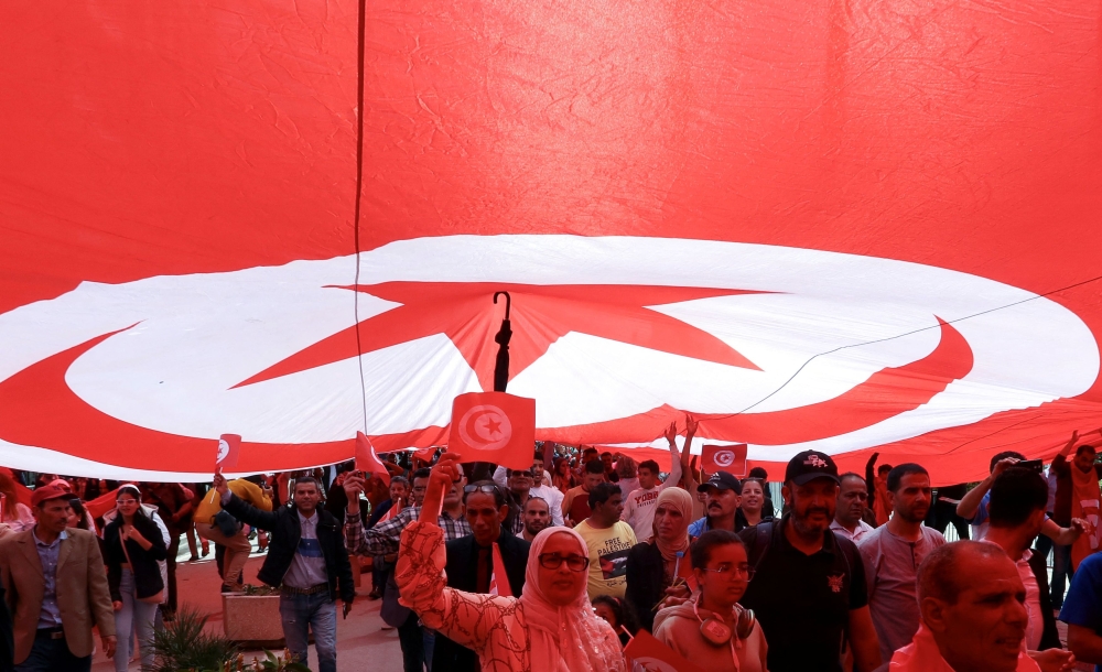 Supporters of Tunisian President Kais Saied carry flags during a demonstration to show their support for him and to reject what they say is ‘foreign interference’, in Tunis, Tunisia May 19, 2024. — Reuters pic