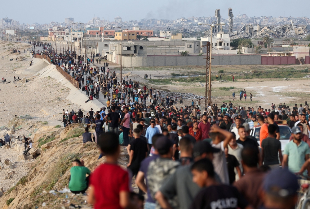 Palestinians gather in the hope of obtaining aid delivered into Gaza through a US-built pier, amid the ongoing conflict between Israel and the Palestinian Islamist group Hamas, as seen from central Gaza Strip, May 19, 2024. — Reuters pic