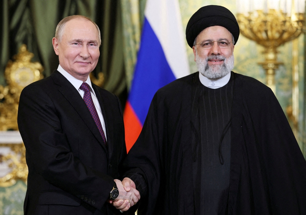 Russian President Vladimir Putin shakes hands with Iranian President Ebrahim Raisi during a meeting in Moscow, Russia December 7, 2023. — Sputnik/Reuters pool pic.