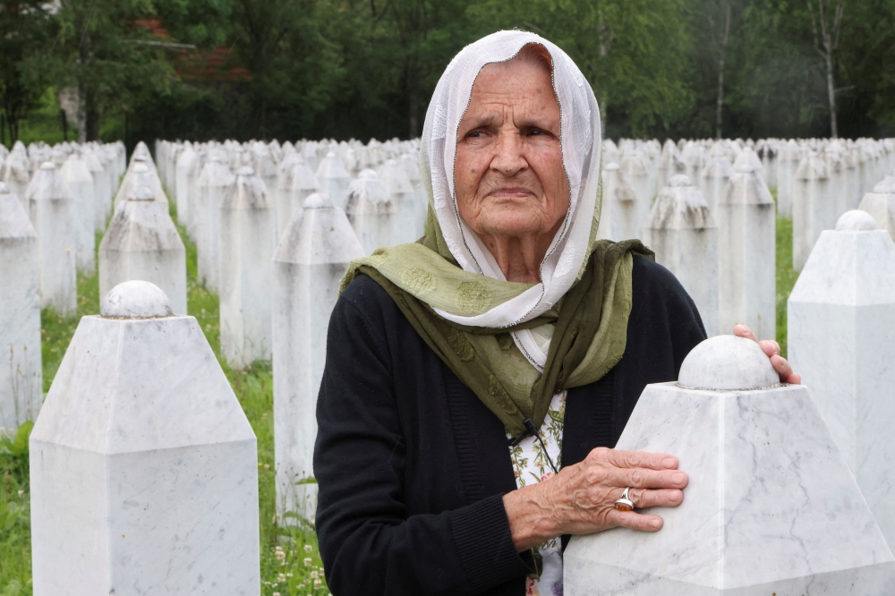 Kada Hotic touches a grave stone at the memorial cemetery in Srebrenica, Bosnia and Herzegovina, May 14, 2024. — Reuters pic