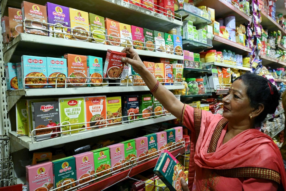 A woman buys packets of MDH and Everest spices at a store in Amritsar on May 21, 2024. — AFP pic