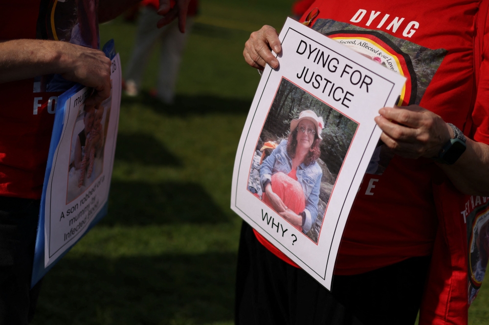 People impacted by the contaminated blood scandal hold placards as they gather in Westminster for a vigil to remember those that lost their lives, ahead of the release of final report of the Infected Blood Inquiry on Monday, in London, Britain, May 19, 2024. — Reuters pic