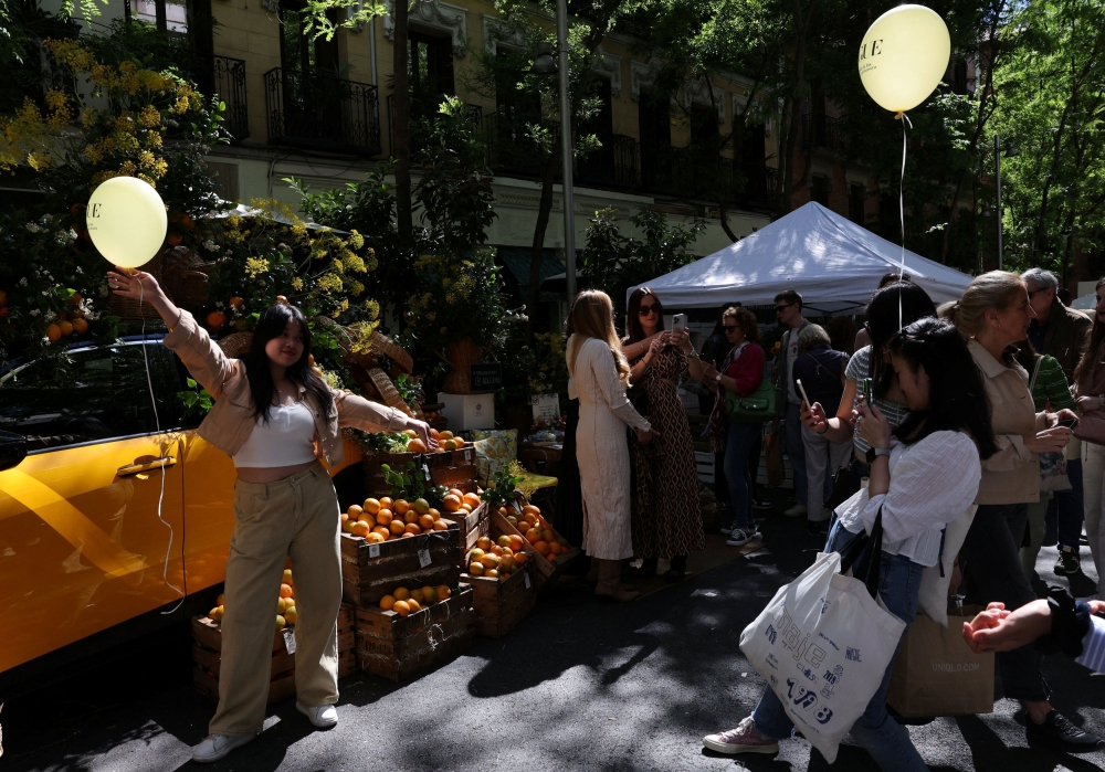 Tourists from China take photos at an outdoor market in the downtown district of Salamanca, in Madrid May 18, 2024. — Reuters pic  