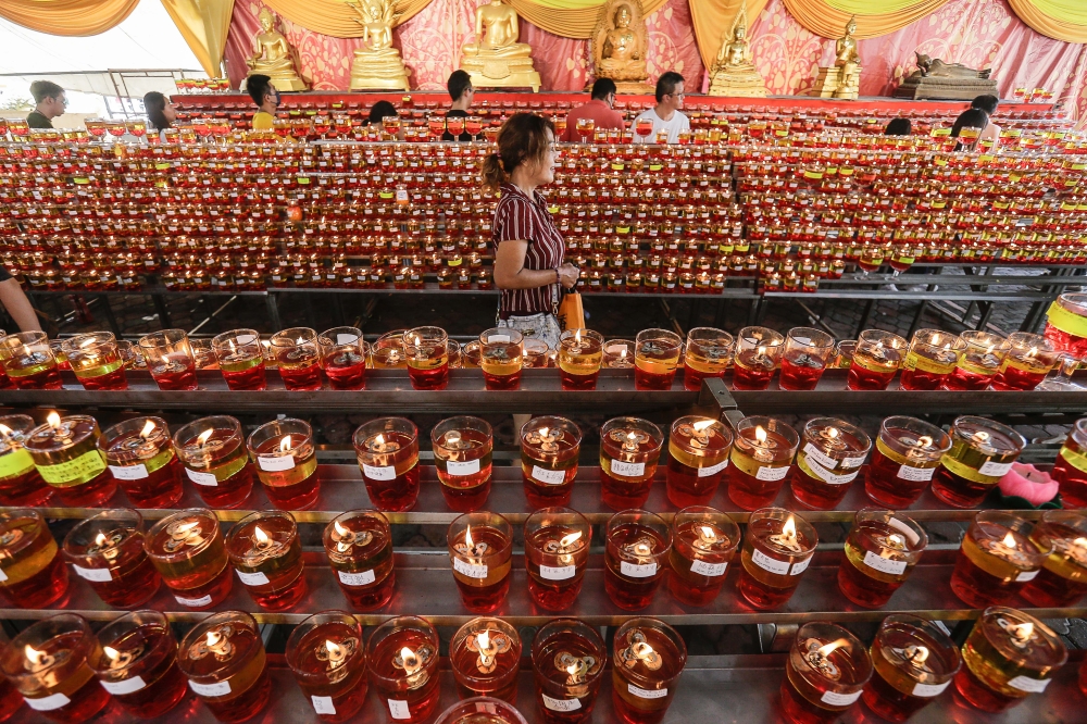 Devotees place candles as they offer prayers during the Wesak Day celebration at the Thai Buddhist Chetawan Temple in Petaling Jaya. — Picture by Sayuti Zainudin
