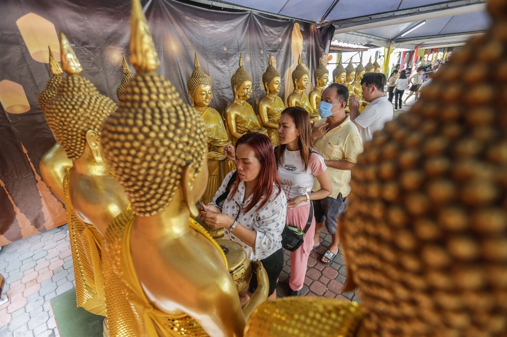 Devotees line up as they offer their prayers during the Wesak Day here at Thai Buddhist Chetawan Temple in Petaling Jaya, May 22, 2024. — Picture by Sayuti Zainudin
