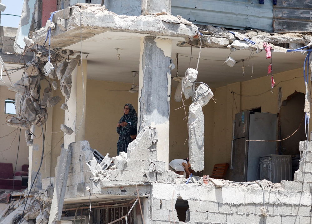 A Palestinian woman looks on from a house which was destroyed in an Israeli strike, amid the ongoing conflict between Israel and Hamas, in Khan Younis, in the southern Gaza Strip, May 22, 2024. — Reuters pic