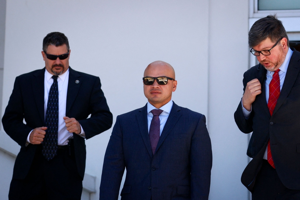 Walt Nauta (centre), aide to former US President Donald Trump, leaving the courthouse in Florida yesterday. — AFP pic