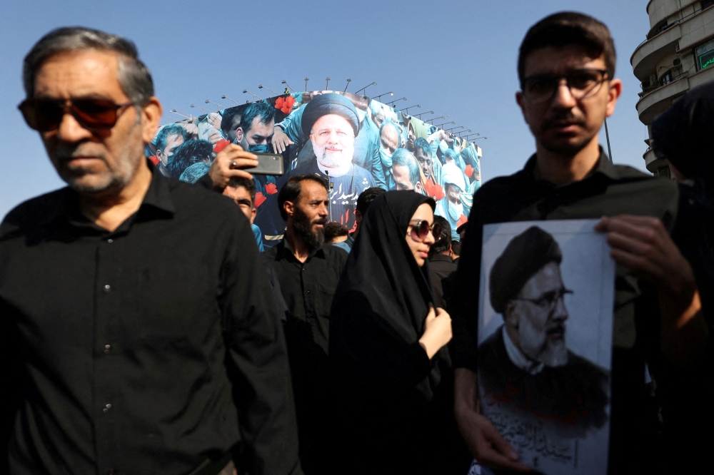 Mourners attend a funeral for victims of the helicopter crash that killed Iran's President Ebrahim Raisi, Foreign Minister Hossein Amirabdollahian and others, in Tehran, Iran, May 22, 2024. — Wana pic via Reuters