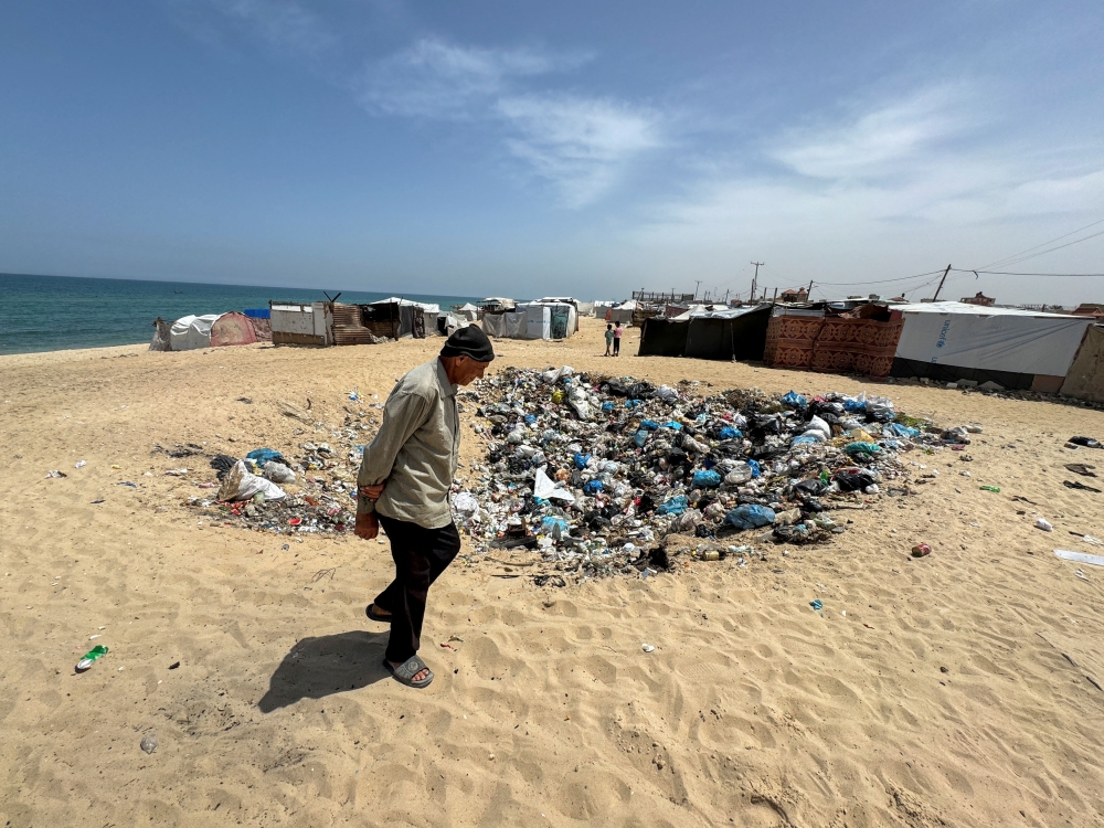 A displaced Palestinian man, who fled his house due to Israel's military offensive, walks next to garbage at a tent camp, amid the ongoing conflict between Israel and Palestinian Islamist group Hamas, in Rafah, in the southern Gaza Strip May 23, 2024. — Reuters pic