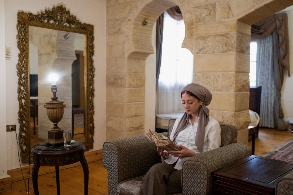 Salma looks at her journal at her home in Cairo after She left Gaza, in Cairo, Egypt May 18, 2024. — Reuters pic