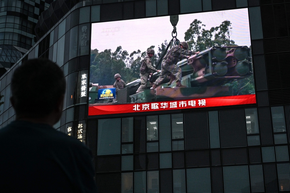 An outdoor screen shows a news coverage of China military drills around Taiwan, in Beijing on May 23, 2024. — AFP pic