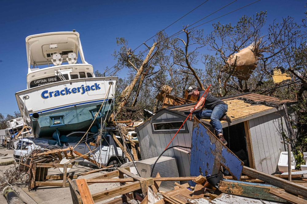 People clear debris in the aftermath of Hurricane Ian in Fort Myers Beach, Florida on September 30, 2022. — AFP file pic