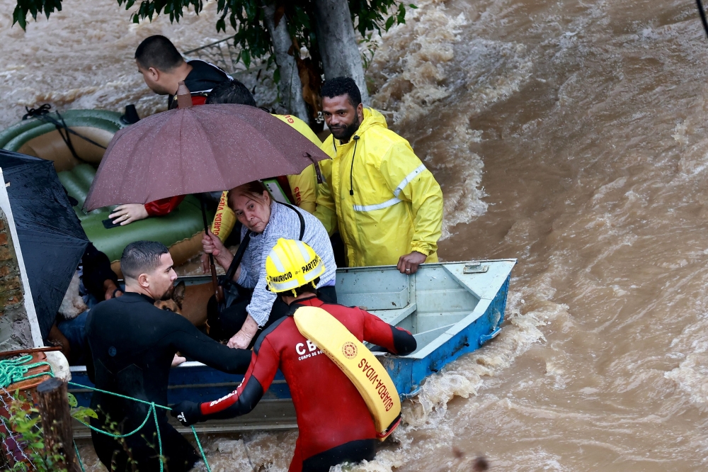Rescue workers evacuate an elderly woman from Cavalhada, after heavy rains in Porto Alegre, May 23, 2024. 