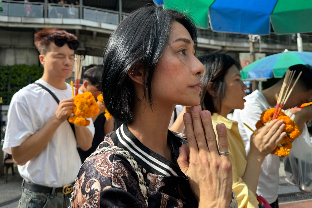 Eva Khoo, who has relatives in hospital after being injured on the turbulence-hit Singapore Airlines flight SQ321 from London to Singapore, prays at the Buddhist Erawan Shrine in Bangkok May 24, 2024.  — AFP pic