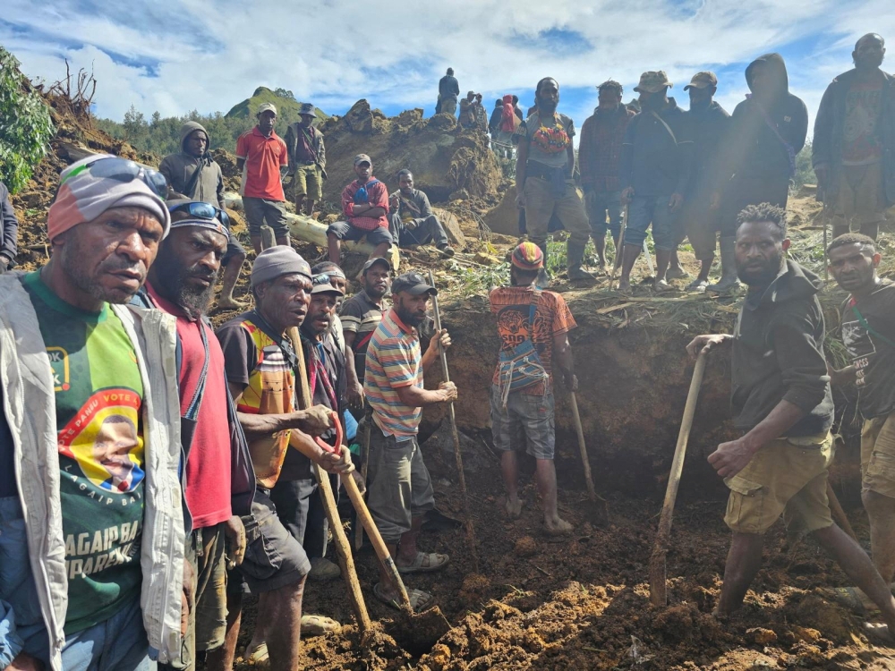 A locals gather amid the damage after a landslide in Maip Mulitaka, Enga province, Papua New Guinea May 24, 2024 in this obtained image. Emmanuel Eralia via REUTERS THIS IMAGE HAS BEEN SUPPLIED BY A THIRD PARTY. MANDATORY CREDIT. NO RESALES. NO ARCHIVES.?