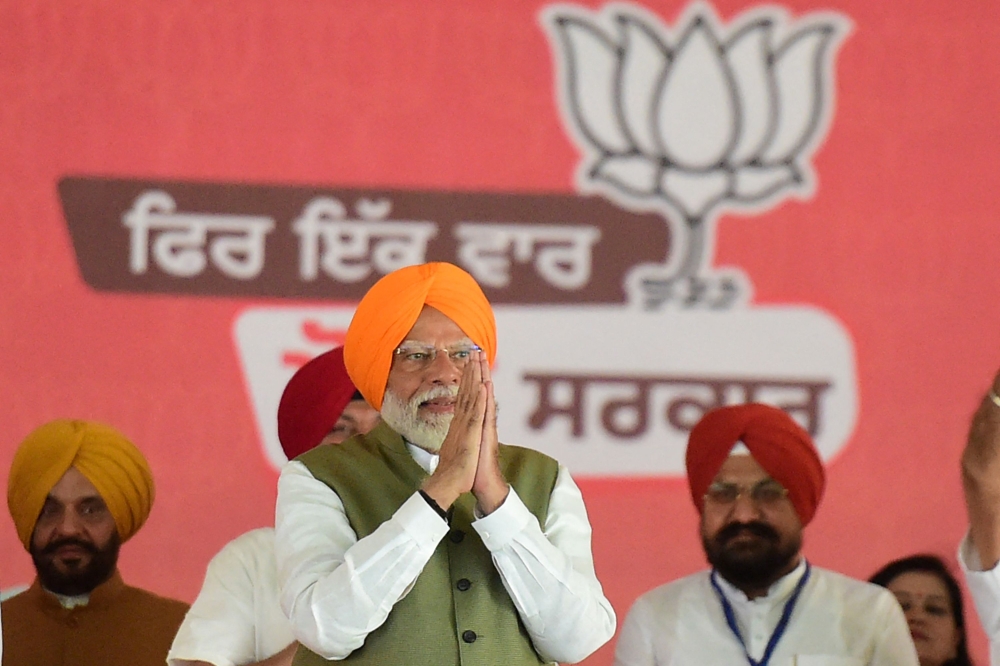 India's Prime Minister Narendra Modi (centre) greets his supporters during an election campaign rally, in Jalandhar on May 24, 2024, on the eve of the sixth phase of voting in India's general election. — AFP pic