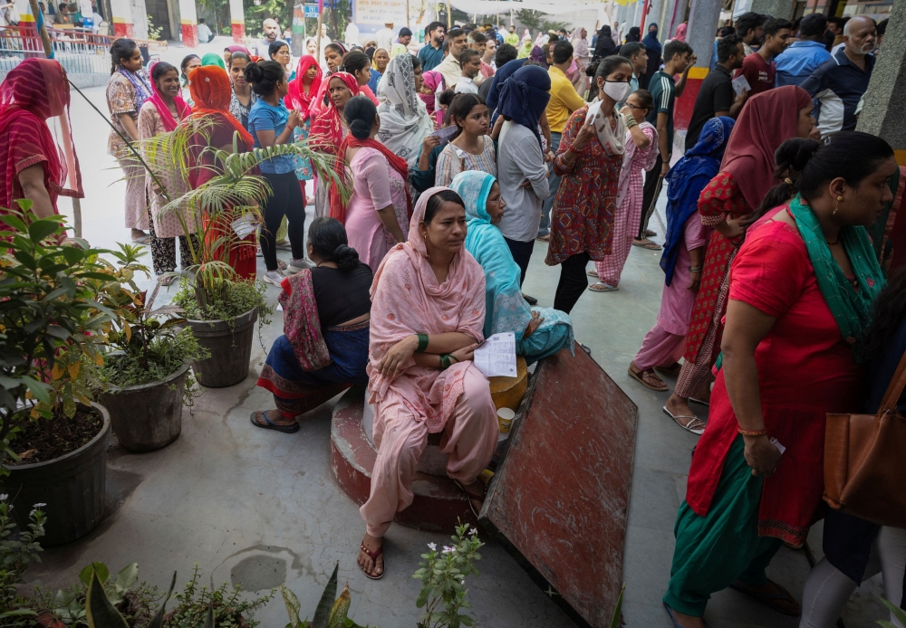 Voters sit in the shade on a hot summer day, as they wait to cast their vote at a polling station during the sixth phase of the general election, in New Delhi, India, May 25, 2024. — Reuters pic