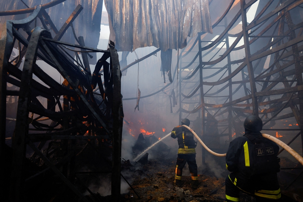 Firefighters work at the site of a household item shopping mall which was hit by a Russian air strike, amid Russia's attack on Ukraine, in Kharkiv, Ukraine, May 25, 2024. — Reuters pic