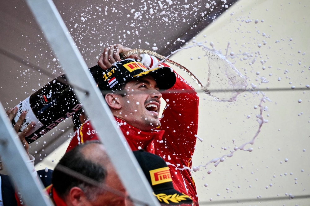Race winner Ferrari’s Monegasque driver Charles Leclerc celebrates with champagne on the podium of the Formula One Monaco Grand Prix at the Circuit de Monaco May 26, 2024. — AFP pic