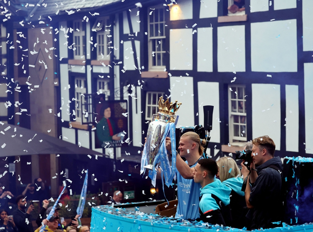 Manchester City's Erling Braut Haaland and Phil Foden with the Premier League trophy on the bus during the victory parade in Manchester May 26, 2024. — Reuters pic