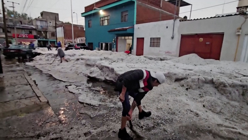 People remove thick ice from a street following a hailstorm amid heat wave, in Puebla, Mexico May 24, 2024. — Reuters pic