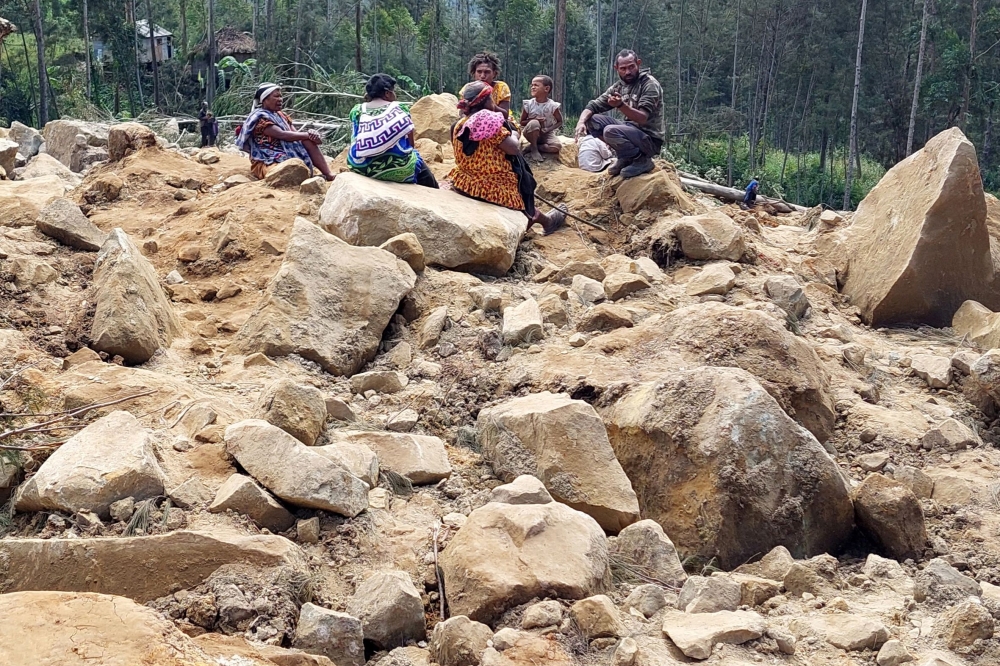 Family members of missing villagers at the site of a landslide. — AFP