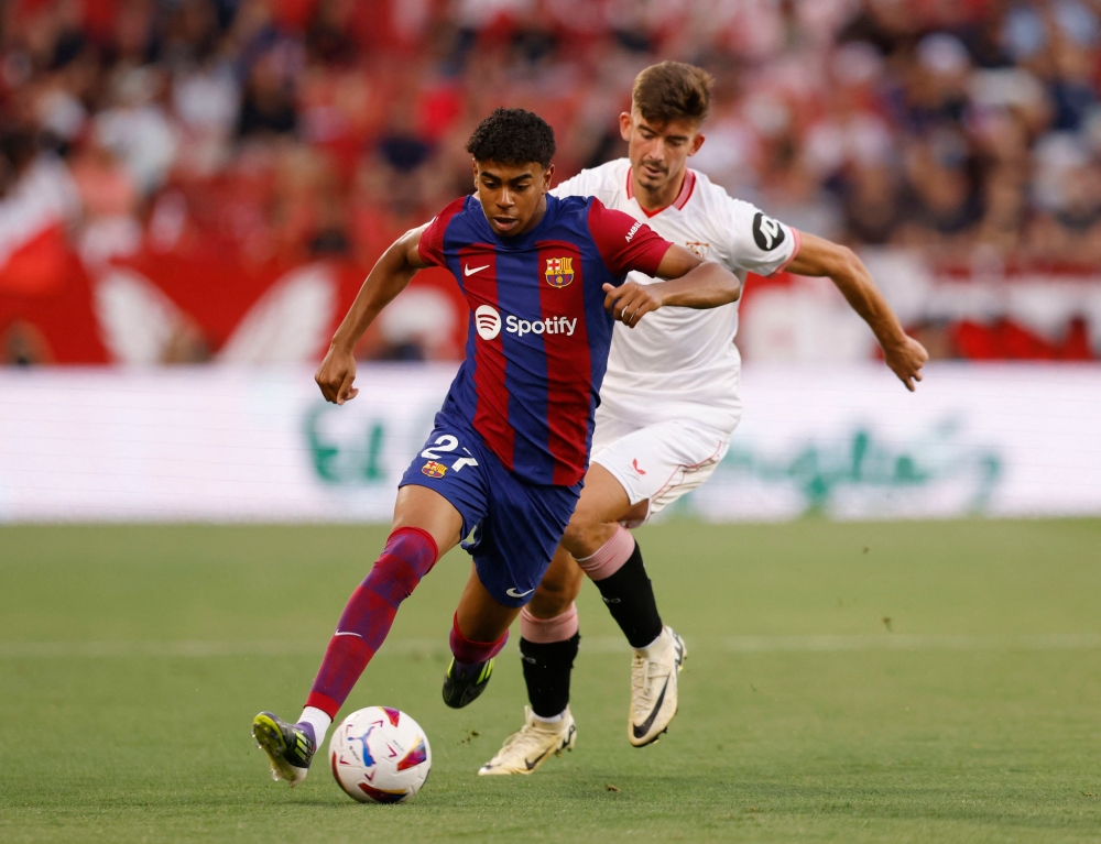 FC Barcelona’s Lamine Yamal in action with Sevilla’s Kike Salas at Estadio Ramon Sanchez Pizjuan, Seville, May 26, 2024. — Reuters pic 