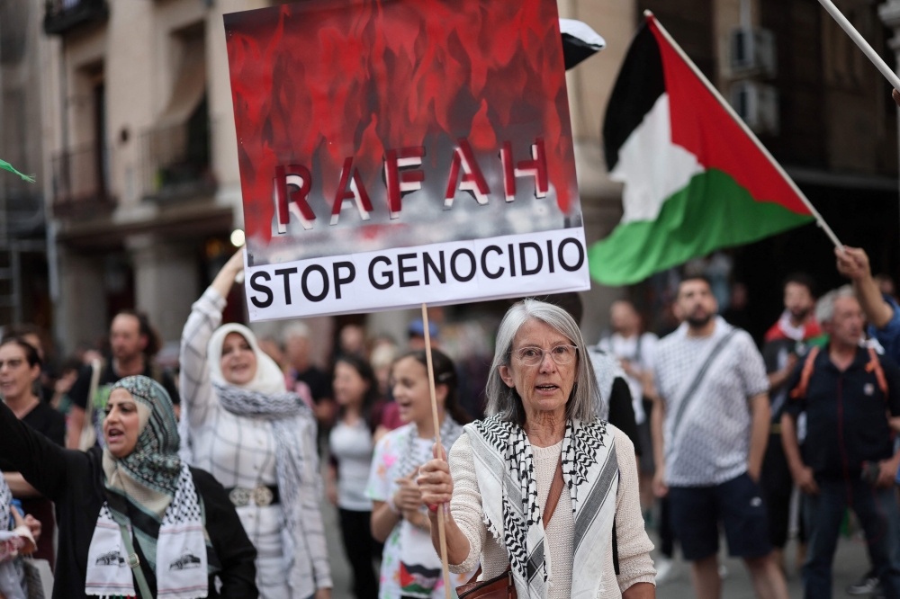 A protestor holds a sign reading 