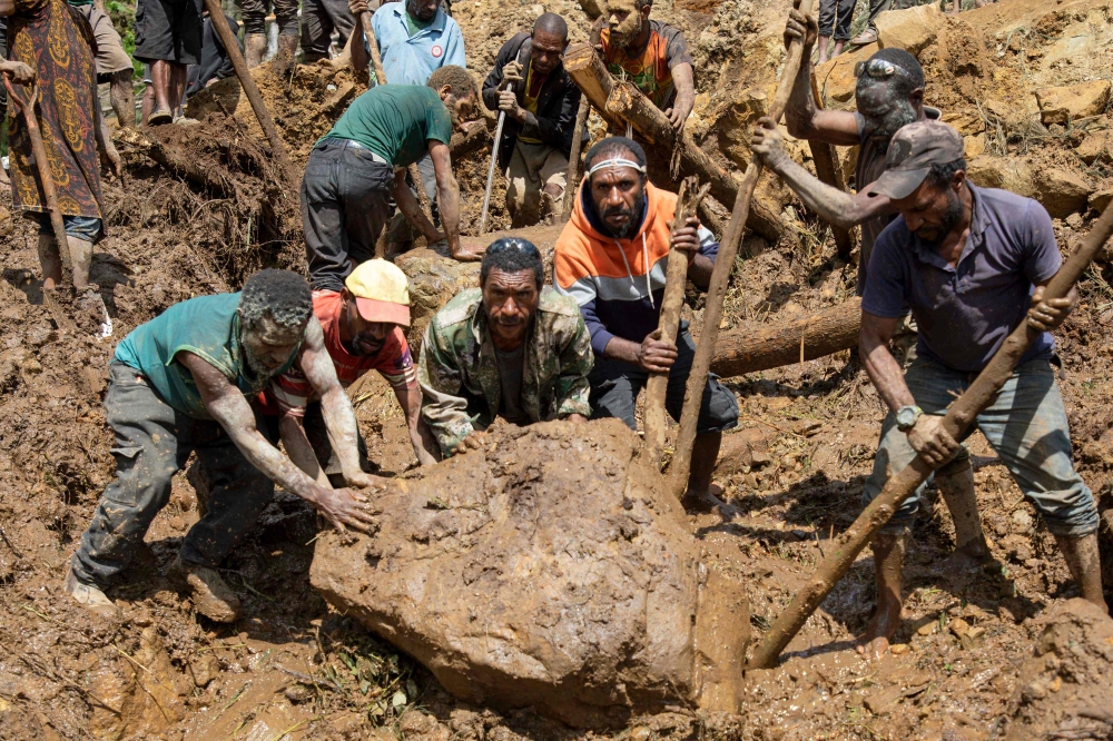 This undated handout photo taken by the UN Development Programme and released on May 28, 2024 shows locals digging at the site of a landslide at Mulitaka village in the region of Maip Mulitaka, in Papua New Guinea's Enga Province. — Handout via UN Development Programme via AFP