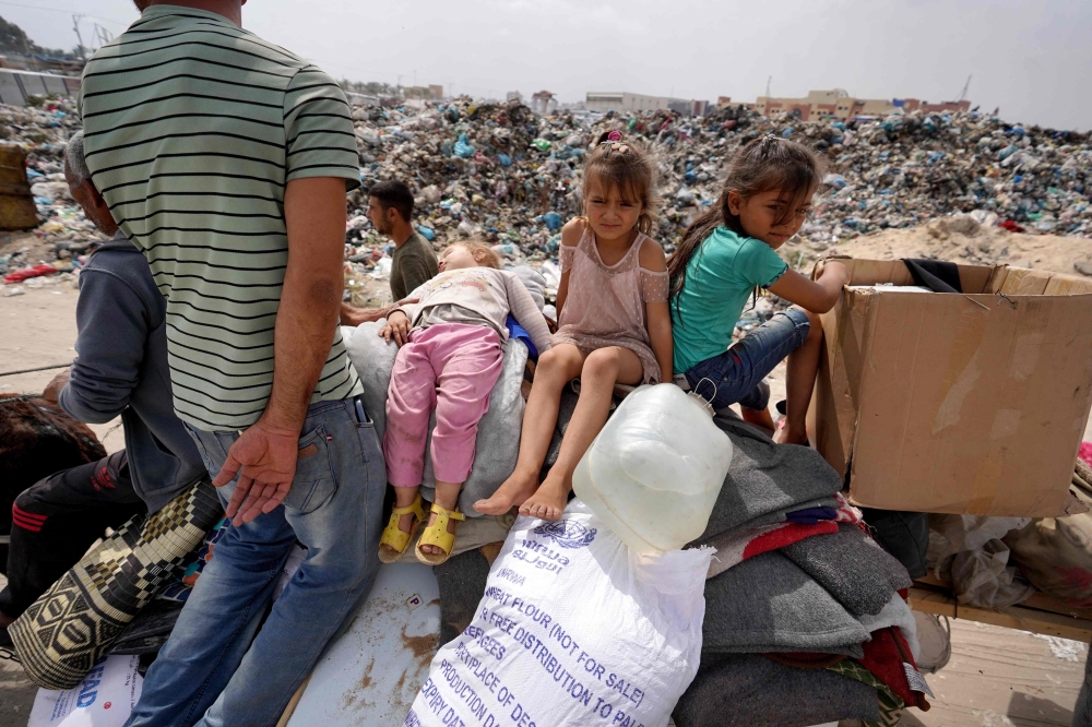 Palestinian children sit on their family's belongings upon their arrival in Khan Yunis from Rafah as people moved to safer areas further north in the southern Gaza Strip, following renewed Israeli strikes on May 28, 2024 amid continuing battles between Israel and Hamas. Israel again bombarded Gaza's far-southern Rafah area on May 28 despite a global storm of outrage over a strike that set ablaze a crowded tent city the previous day. — AFP pic