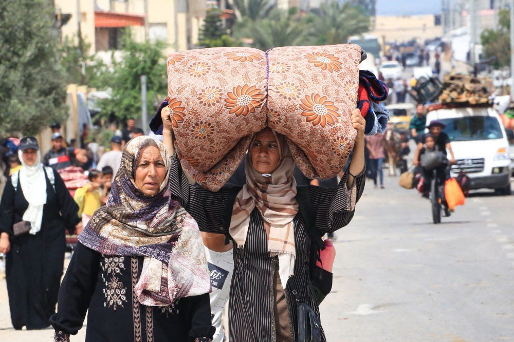 Palestinians fleeing Rafah with their belongings following renewed Israeli strikes in the city. — AFP pic