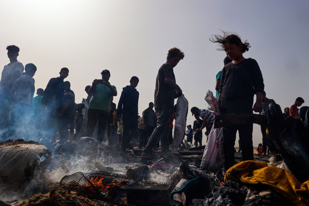 Palestinians gather at the site of an Israeli strike on a camp area housing internally displaced people in Rafah. — AFP pic