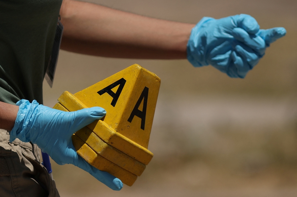 A forensic technician works at the crime scene in Mexico. — Reuters pic