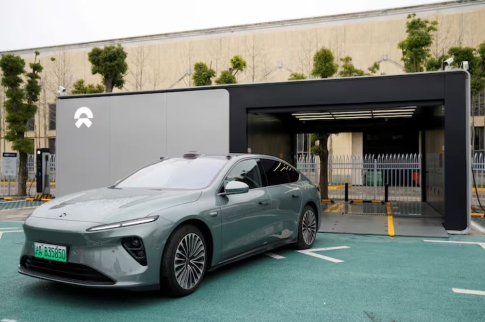 A staff member of Chinese electric vehicle (EV) maker Nio drives a Nio car as he demonstrates to media about the operation of the new battery swapping station, at a delivery center of the company, in Nanxiang, Shanghai, China March 23, 2023. — Reuters pic